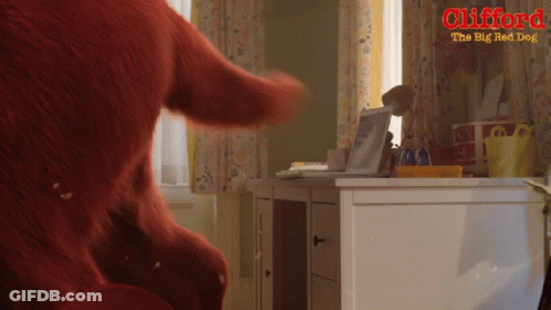 An Advertisement For Clifford The Big Red Dog Shows A Stuffed Animal On A Desk GIF