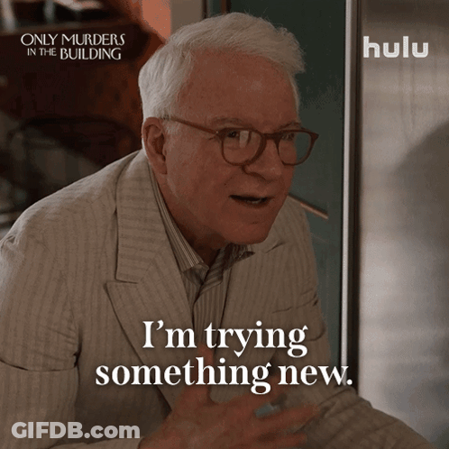 An Advertisement For Only Murders In The Building Shows A Man In A Suit And Glasses Saying I 'M Trying Something New GIF