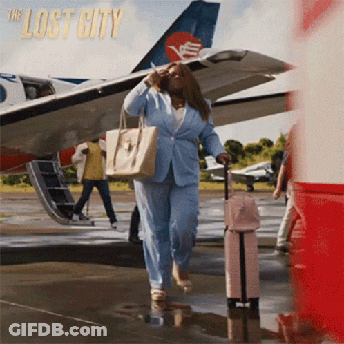 Woman In Blue Suit Carrying Suitcase Lost City GIF