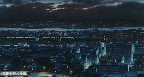 An Aerial View Of A City At Night With Cars On The Road GIF