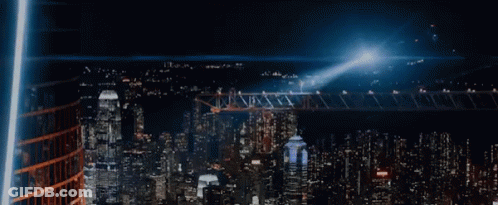 An Aerial View Of A City At Night With Lots Of Buildings Lit Up GIF