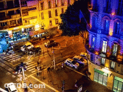 An Aerial View Of A City Street At Night With Cars Parked On The Side Of The Road GIF