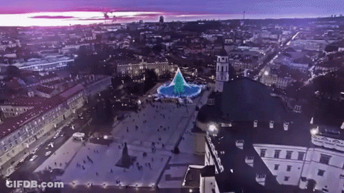 An Aerial View Of A City With A Christmas Tree In The Center GIF