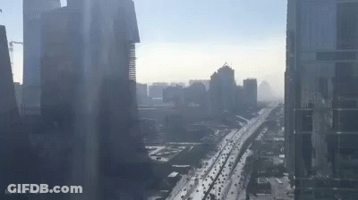 An Aerial View Of A City With A Highway And A Lot Of Traffic . GIF