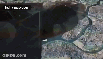 An Aerial View Of A City With A River Running Through It And A Large Hole In The Ground . GIF
