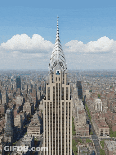 An Aerial View Of A City With A Tall Building In The Foreground GIF