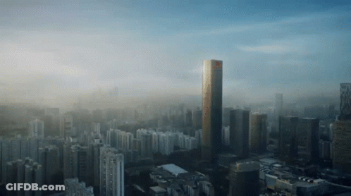 An Aerial View Of A City With A Very Tall Building In The Foreground GIF