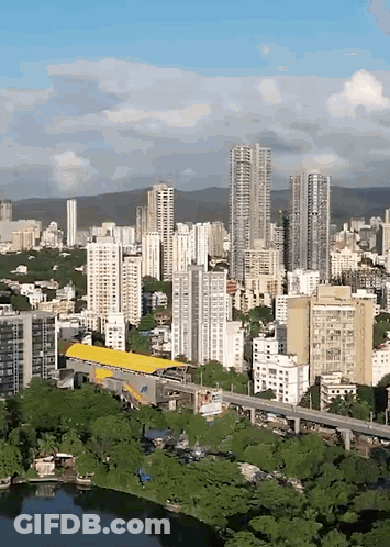 An Aerial View Of A City With Tall Buildings And Trees GIF