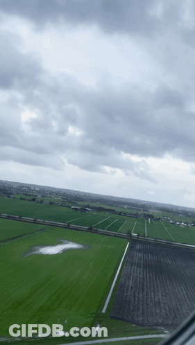 An Aerial View Of A Field With A Cloudy Sky In The Background GIF