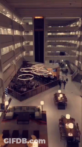 An Aerial View Of A Hotel Lobby With Tables Chairs And Lamps GIF