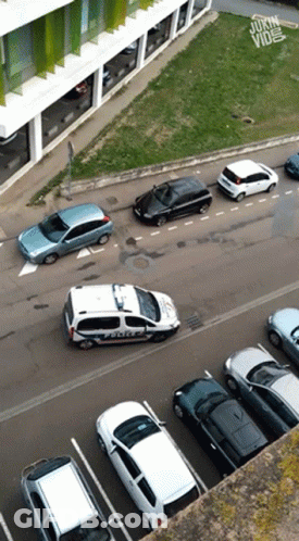 An Aerial View Of A Parking Lot With A Police Car In The Foreground GIF