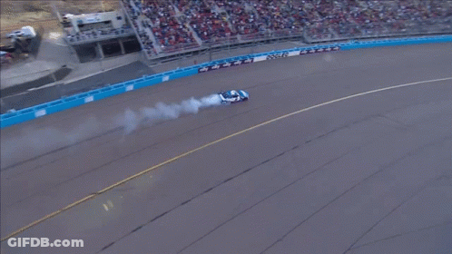 An Aerial View Of A Race Track With A Car That Has Smoke Coming Out Of Its Tires GIF
