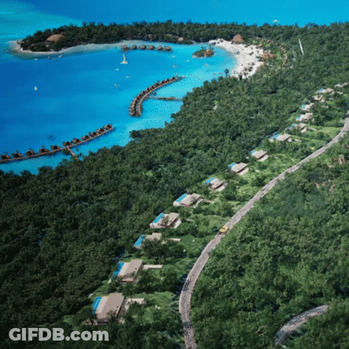 An Aerial View Of A Tropical Island With A Few Houses On It GIF