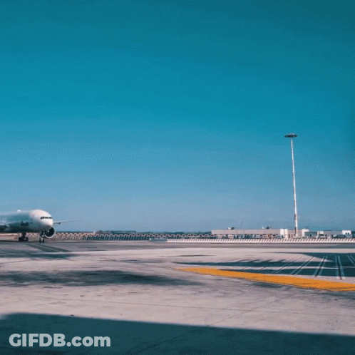 An Airplane Is Parked On A Runway With A Building In The Background That Says Airways GIF