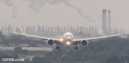 An Airplane Is Taking Off From A Runway With Smoke Coming Out Of Its Wings GIF