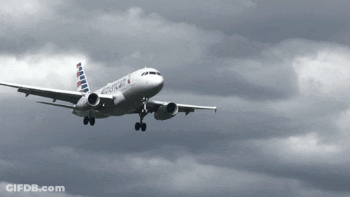 An American Airlines Plane Is Flying In The Clouds GIF
