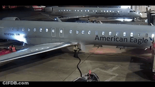 An American Eagle Airplane Is Parked In A Hanger GIF