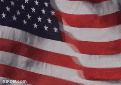 An American Flag Is Waving In The Wind In A Close Up . GIF