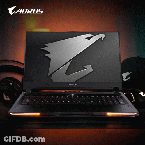 An Aorus Laptop Sits On A Table With Headphones GIF