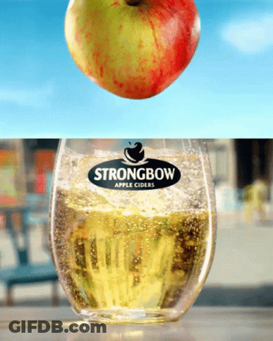An Apple Is Falling Into A Glass Of Strongbow Apple Cider GIF