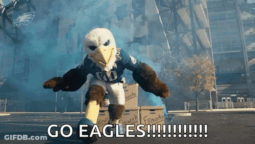 An Eagle Mascot Says Go Eagles In Front Of Boxes Of Fireworks GIF