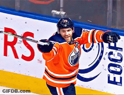 An Edmonton Oilers Hockey Player Holds His Stick Up In The Air GIF