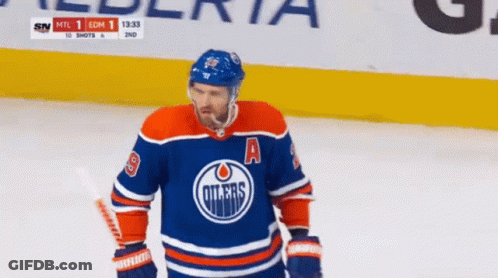 An Edmonton Oilers Hockey Player Is Standing On The Ice GIF