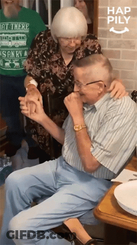An Elderly Couple Holding Hands With A Woman Wearing A Green Shirt That Says Get There GIF