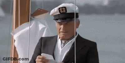An Elderly Man In A Suit And Hat Is Holding A Piece Of Paper In His Hand . GIF