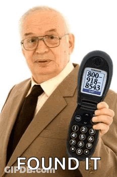 An Elderly Man In A Suit And Tie Is Holding A Flip Phone With A Phone Number On It . GIF
