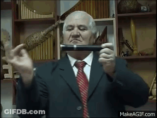 An Elderly Man In A Suit And Tie Is Holding A Pipe In His Hands . GIF