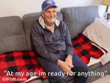 An Elderly Man Is Sitting On A Couch With The Words " At My Age Im Ready For Anything " GIF