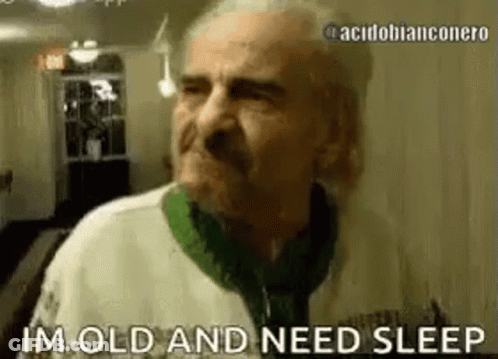 An Elderly Man Is Standing In A Hallway And Saying `` Im Old And Need Sleep '' . GIF