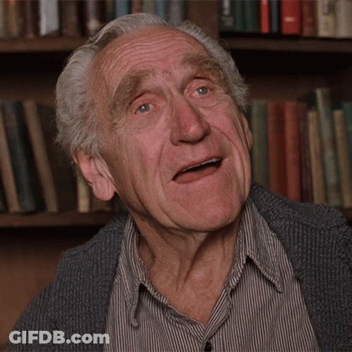 An Elderly Man Making A Funny Face In Front Of Bookshelves GIF