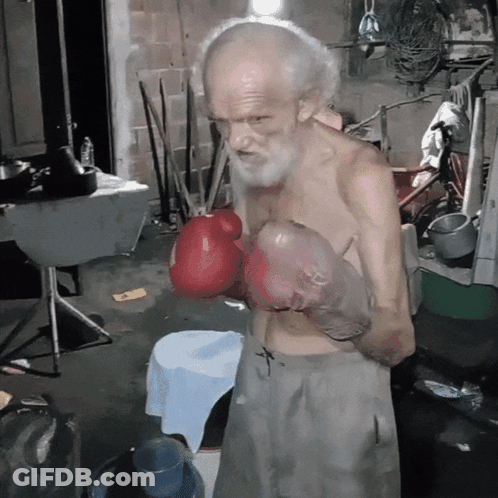 An Elderly Man Wearing Red Boxing Gloves With The Letter H On The Gloves GIF
