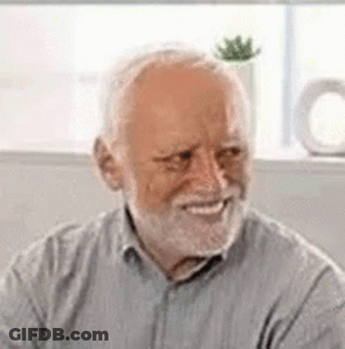 An Elderly Man With A Beard Is Smiling And Looking At The Camera . GIF