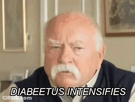 An Elderly Man With A Mustache Is Sitting In A Living Room . GIF