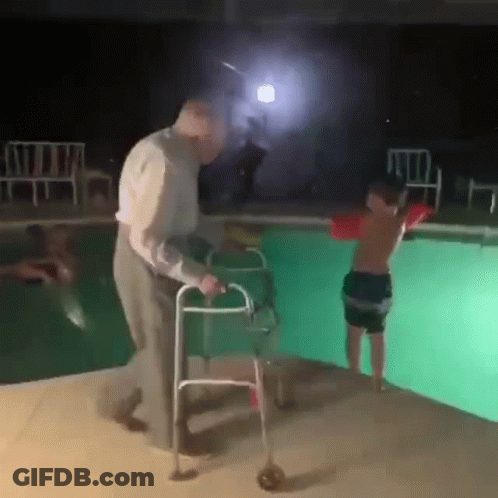 An Elderly Man With A Walker Is Helping A Young Boy With A Life Preserver Into A Swimming Pool . GIF