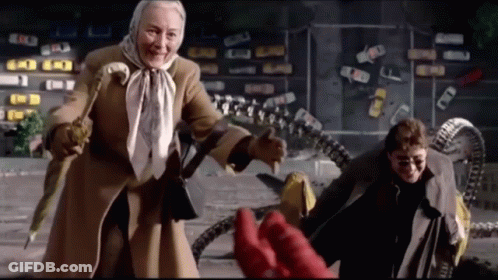 An Elderly Woman In A Scarf Is Standing Next To A Man In A Trench Coat GIF