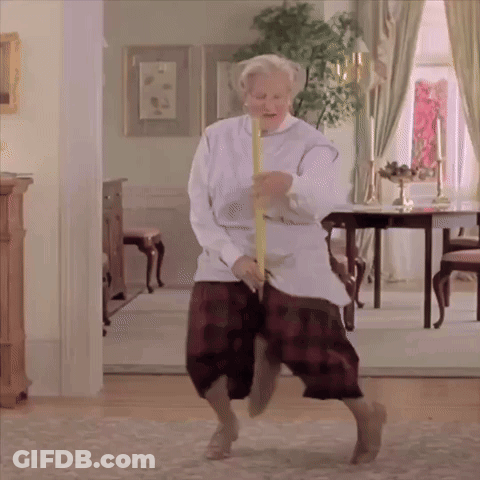 An Elderly Woman Is Dancing In A Living Room With A Yellow Stick GIF