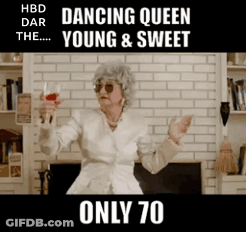 An Elderly Woman Is Holding A Glass Of Wine In Front Of A Fireplace .. GIF