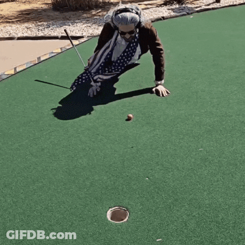 An Elderly Woman Is Playing A Game Of Golf On A Green GIF