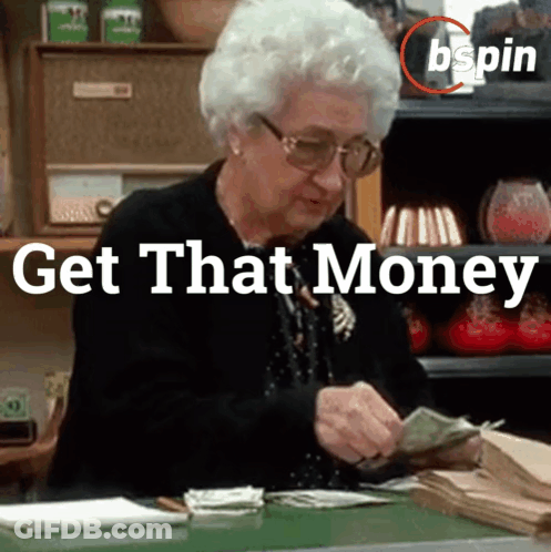 An Elderly Woman Is Sitting At A Desk Counting Money With The Words Get That Money Behind Her GIF