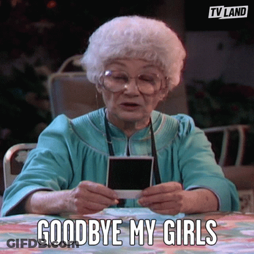 An Elderly Woman Is Sitting At A Table Holding A Photo And Saying Goodbye My Girls GIF