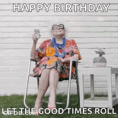 An Elderly Woman Is Sitting In A Chair Holding A Glass Of Beer And A Birthday Card . GIF