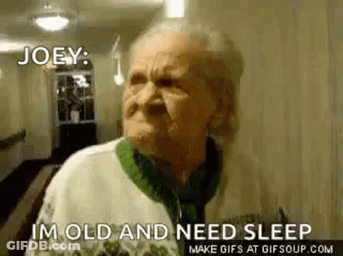 An Elderly Woman Is Standing In A Hallway And Making A Funny Face . GIF