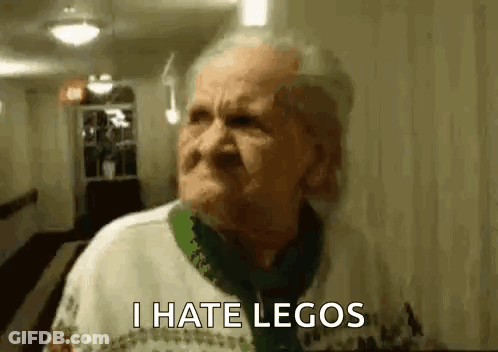 An Elderly Woman Is Standing In A Hallway With A Serious Look On Her Face And Says `` I Hate Legos '' . GIF