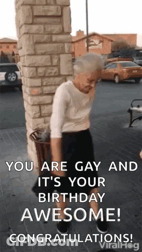 An Elderly Woman Is Standing In Front Of A Brick Wall And Holding A Trash Can . GIF