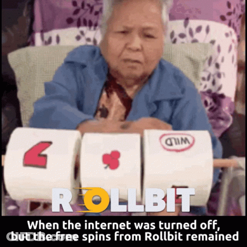 An Elderly Woman Sits In Front Of A Machine That Says Rollbit On It GIF