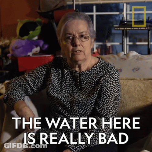An Elderly Woman Sitting On A Couch With The Words " The Water Here Is Really Bad " GIF